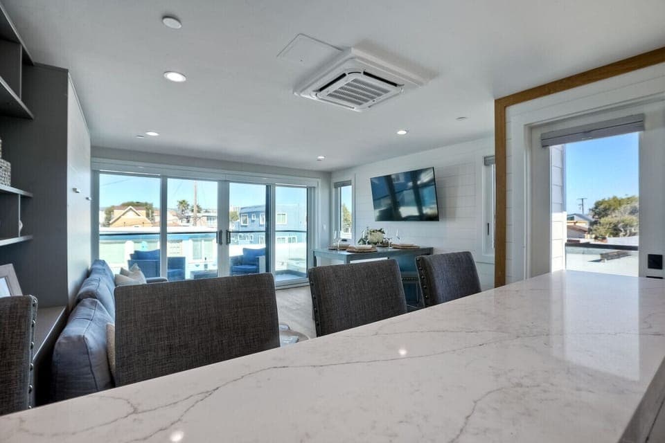 OPEN-CONCEPT KITCHEN VIEW OVER LIVING AREA & BALCONY – The kitchen overlooks the living space and extends toward the balcony, creating a bright, airy, and seamlessly connected open-concept layout.