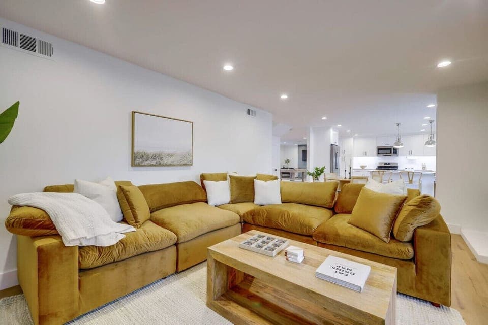 Bright open living room w/ plush seating, clean lines & easy flow into the kitchen for relaxed group hangouts.