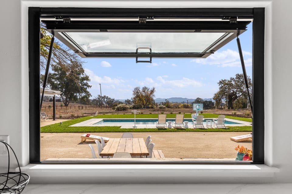 view of back patio and pool area from kitchen hydraulic pass-thru window