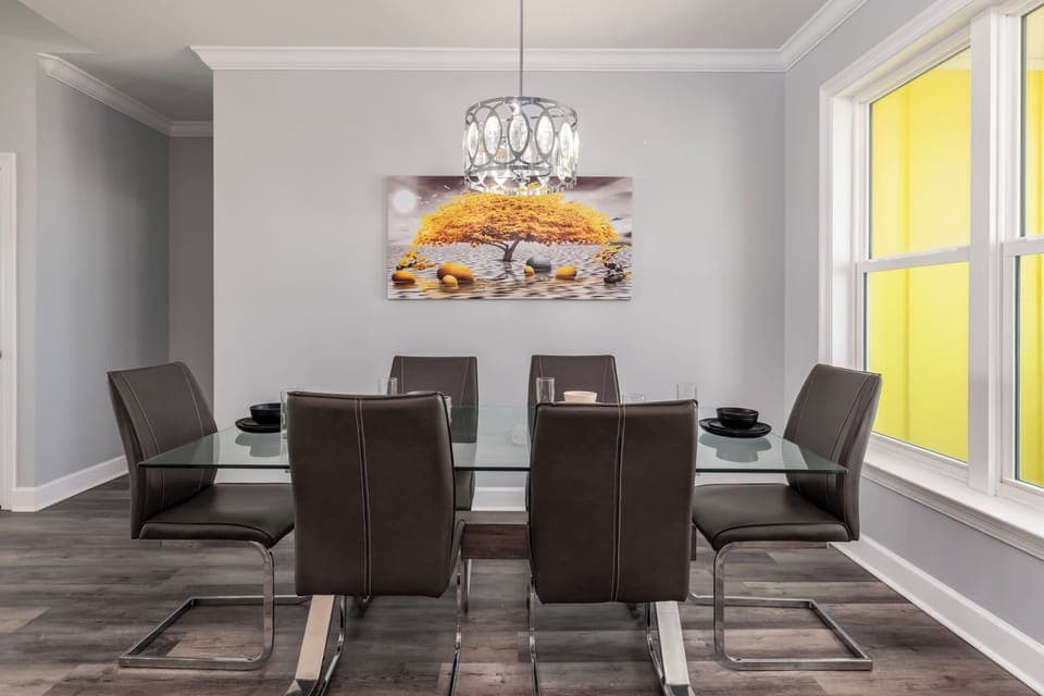 Gather around your elegant glass dining table, where sophisticated meals become memorable moments beneath the stylish pendant lighting.