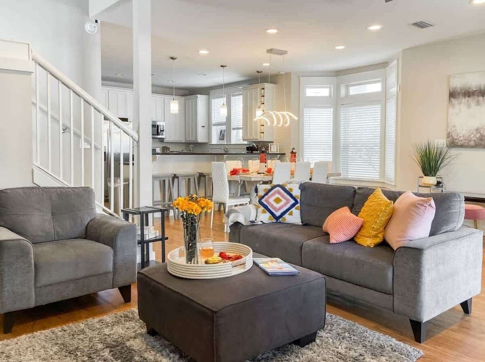 [First Floor] Modern living room with seating for 8-10 people and 60-inch smart TV.