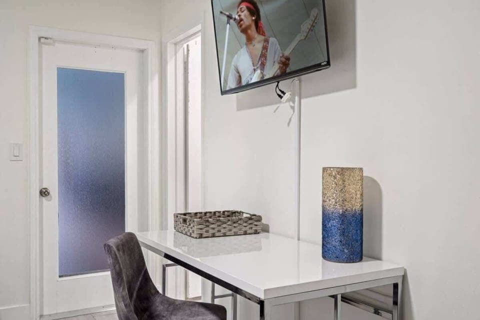 - Work desk with TV above for streaming or relaxing moments  
- Modern chair and bright decor create a stylish workspace  
- Perfect for remote work while enjoying your vacation stay