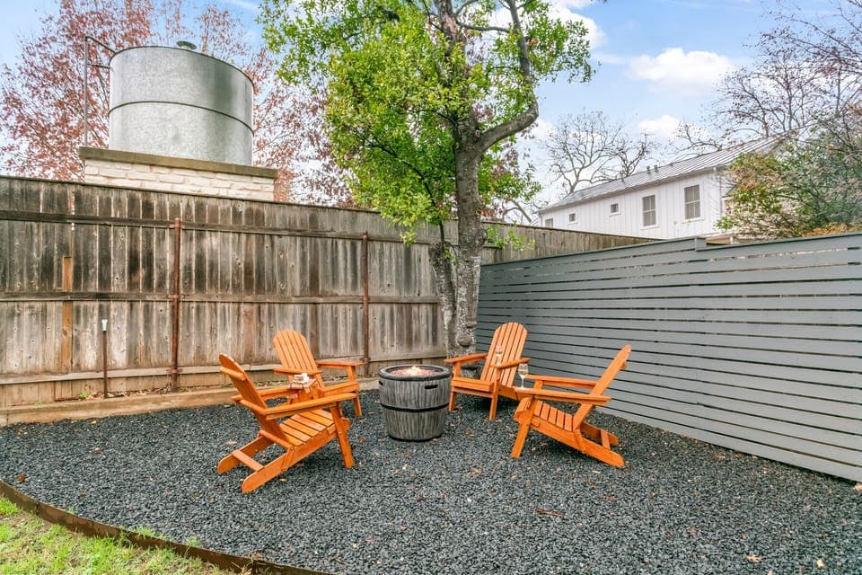 Gather 'round the fire pit with friends in this cozy backyard setup