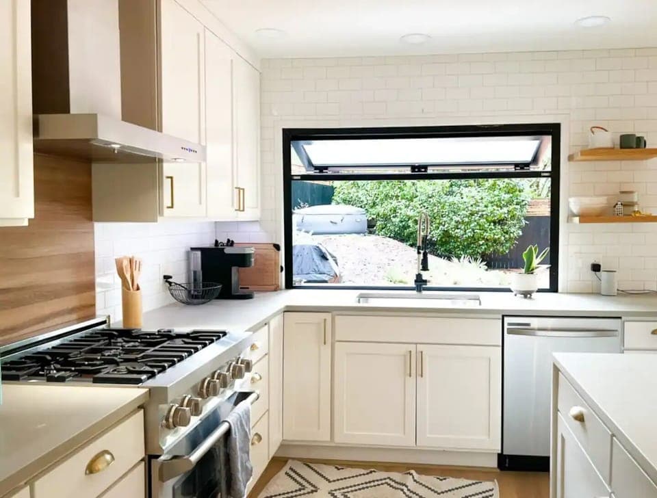 Open kitchen with indoor/outdoor pass-through window to BBQ and small bar. 