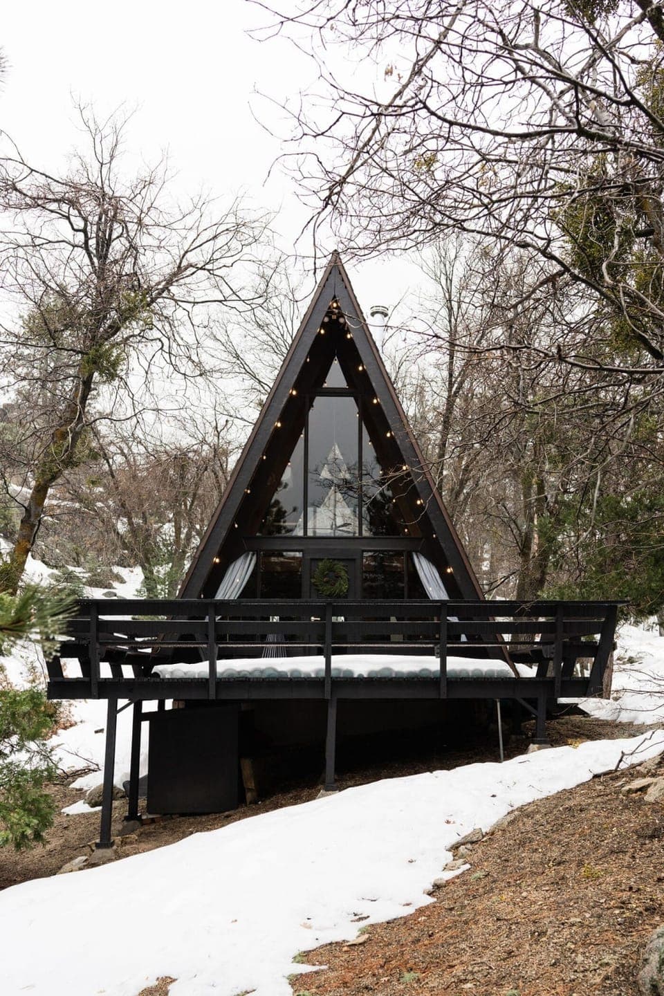 A-Frame cabin nestled in snowy woods