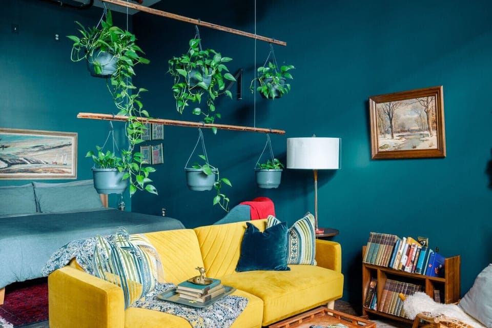 Beautiful yellow couch and dark harbor walls create a rich, moody atmosphere.