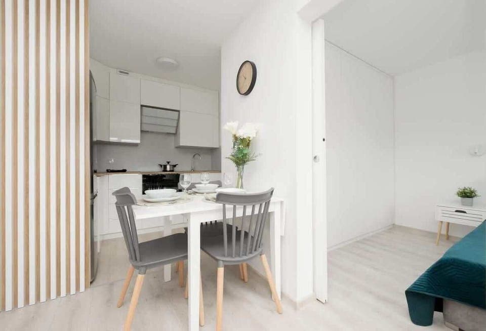 A dining area with a small round table and chairs, seamlessly connected to the kitchen, maximizing space efficiency.

