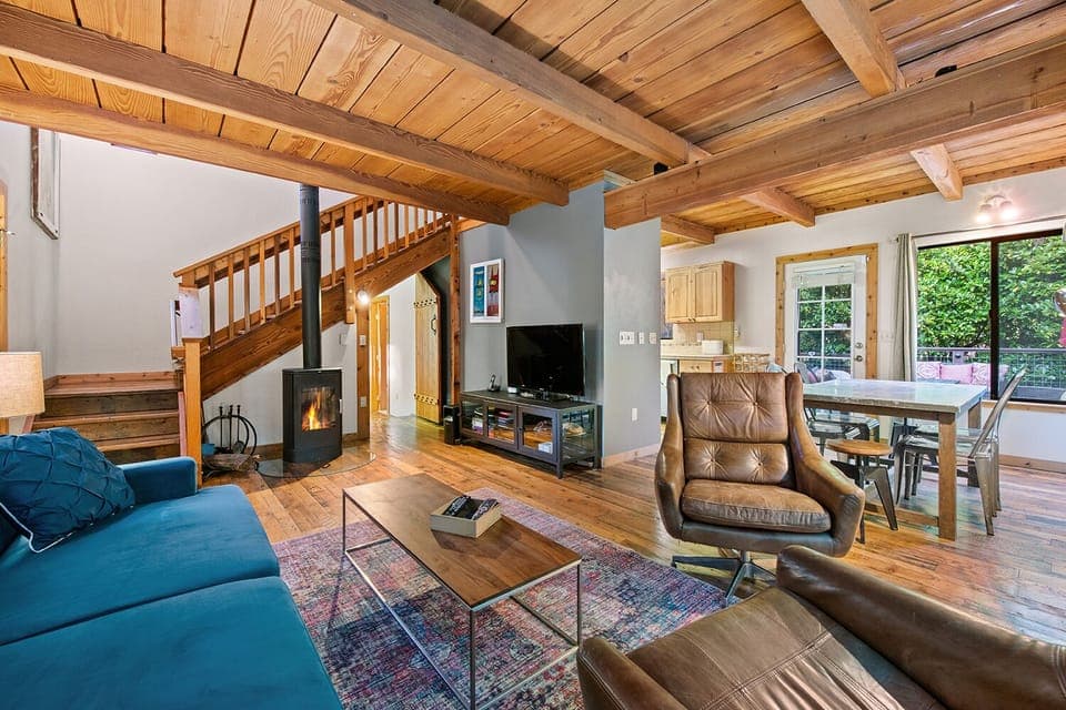 The comfy living room with gas stove and entertainment open to the dining area.