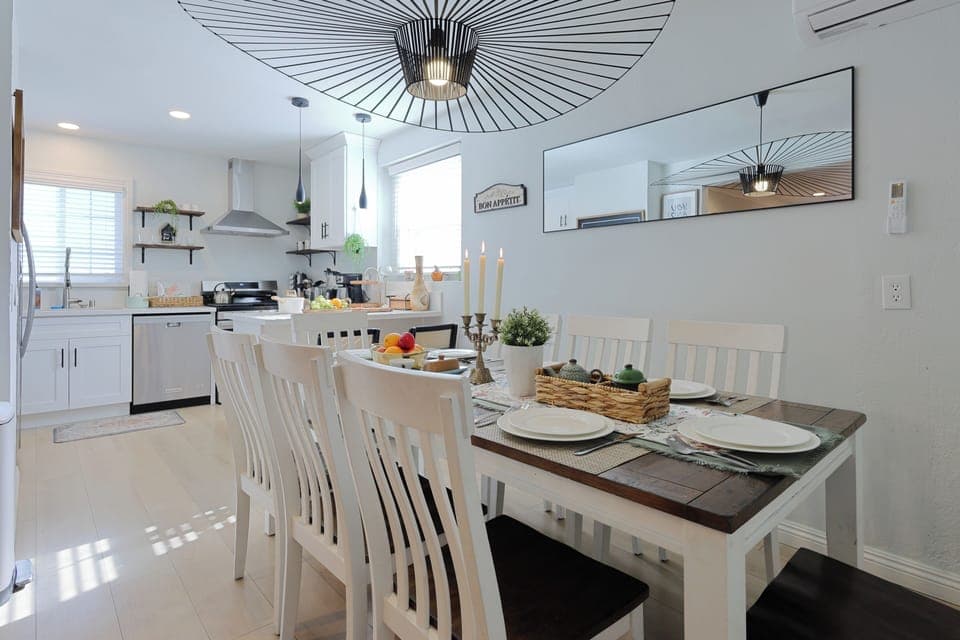 A contemporary dining area seamlessly connected to a modern white kitchen