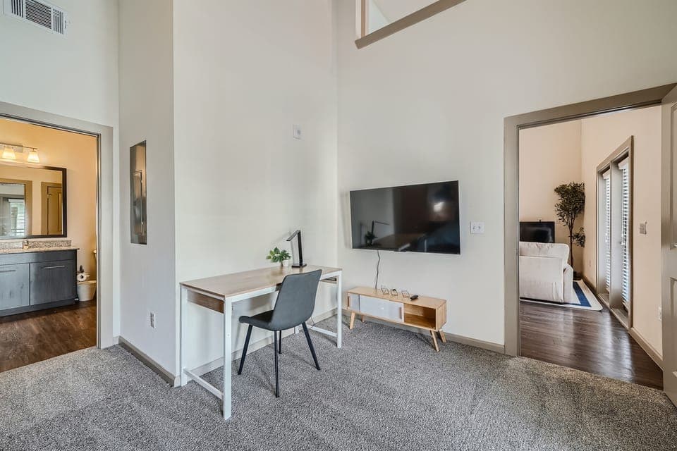 Primary Bedroom with TV, office desk, and chair