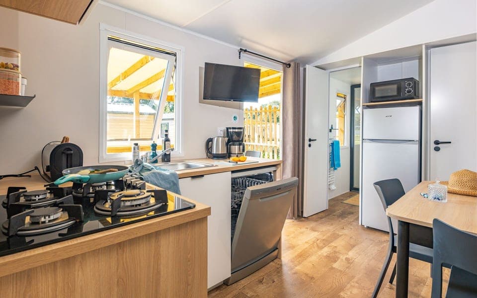 Modern and fully-equipped kitchen with a dining setup for two — ideal for intimate meals or morning coffee.