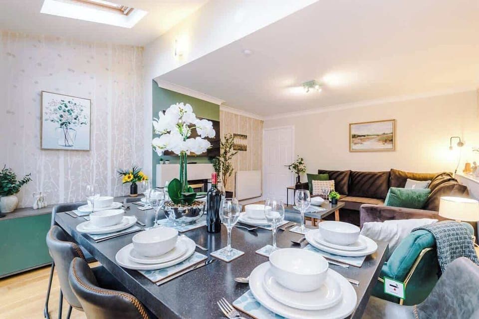 The open-plan living and dining area benefits from a 50-inch SMART TV, a comfortable corner sofa bed, an 8-seater dining table and plenty of space to sit down and relax,