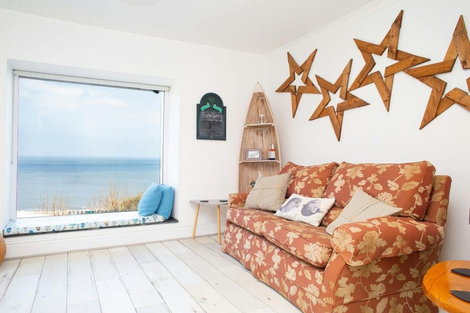 Sitting room with two seater sofa, window sea and stunning sea views
