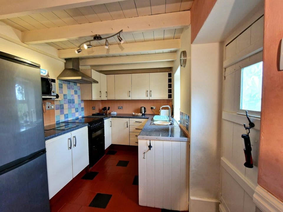 Kitchen with fridge/freezer, microwave, toaster, kettle and electric cooker