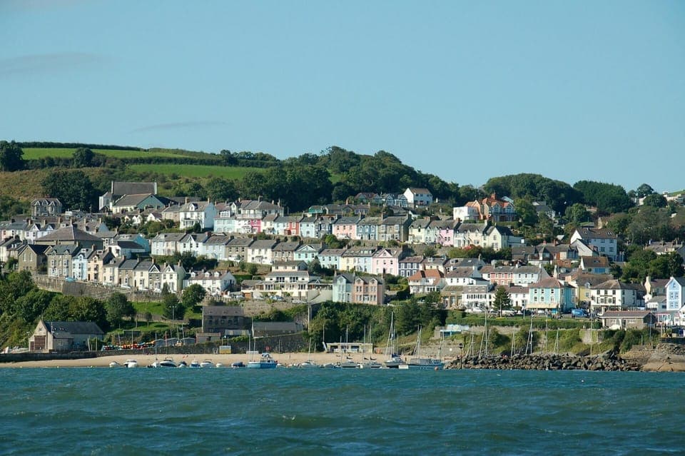 New Quay from the sea, sandy beach, moored boats and colourful houses