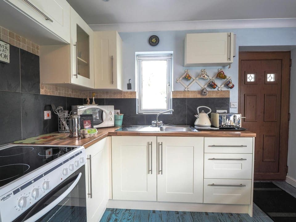 White wall and base cupboards. Electric cooker