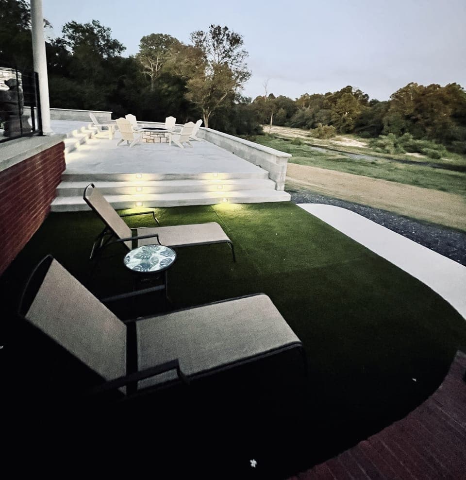 Outdoor living area with lounge area, table & chairs, and a firepit