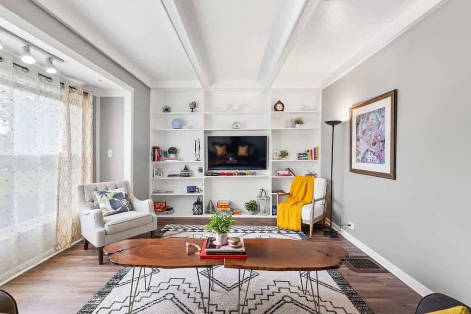 - Bright living room with built-in shelves and flat screen TV   - Stylish wood coffee table and cozy armchairs add charm   - Natural light and modern decor create a relaxing stay  