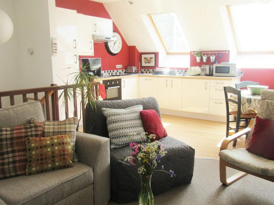 Living area with sofa, armchair, view of kitchen