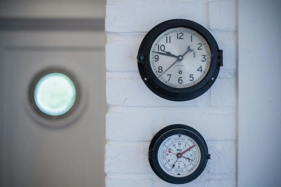 Wall clock and barometer on white painted brick walls