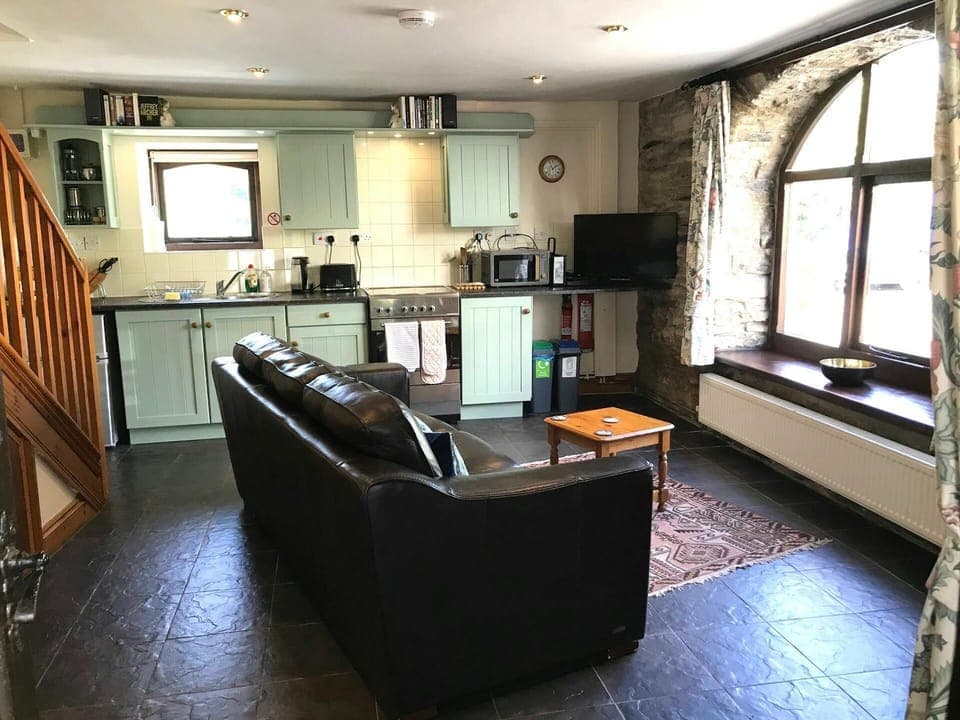 Open plan kitchen/diner: sofa, coffee table and TV; cooker, microwave, kettle and toaster