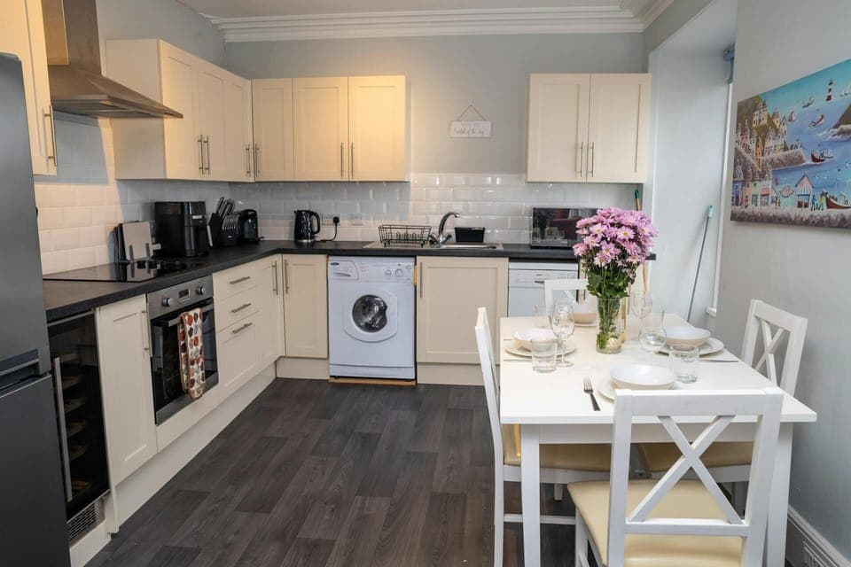 Kitchen with wall and base cupboards, washing machine, dishwasher and fridge/freezer