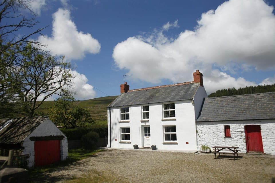 Front of Mynydd Crwn Bach cottage, gravel area and picnic bench