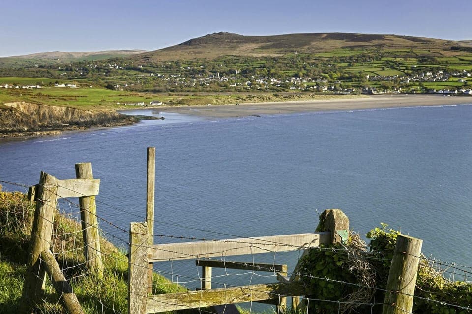 View of Newport bay looking across the sea to the and beach with hills in the distance