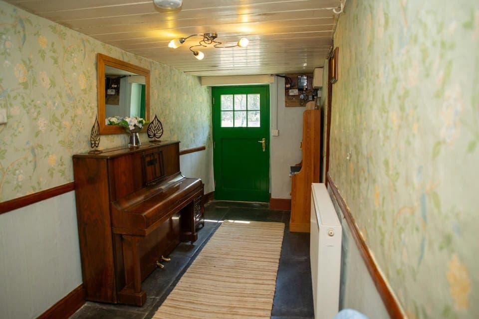 Hallway with piano and mirror above