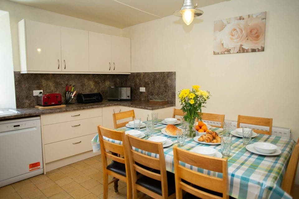 Fitted kitchen/dining area: dishwasher, microwave, toaster, dining table and eight chairs