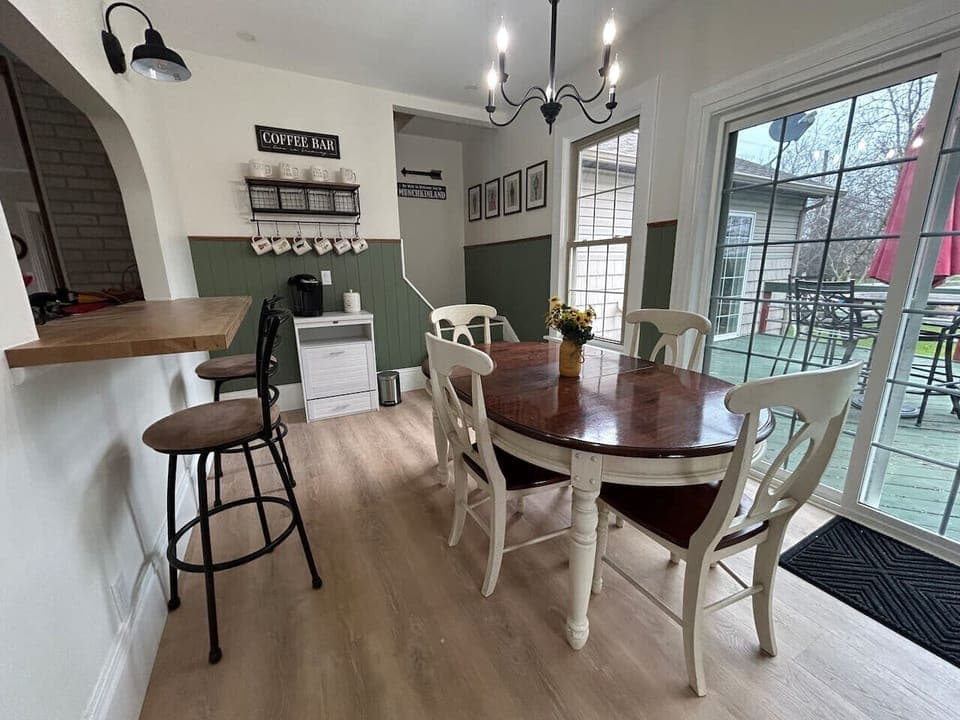 A farmhouse-style dining table, surrounded with four chairs, invites family and friends to gather for hearty meals and lively conversation.  The counter height bar also offers additional seating through the peek-a-boo opening to the kitchen.