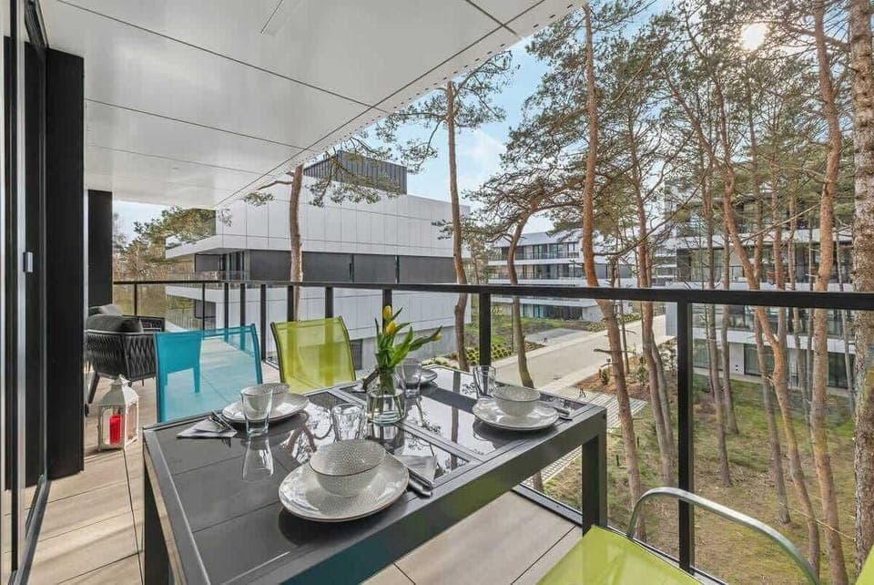 Modern balcony with garden furniture and a view of the pine forest.