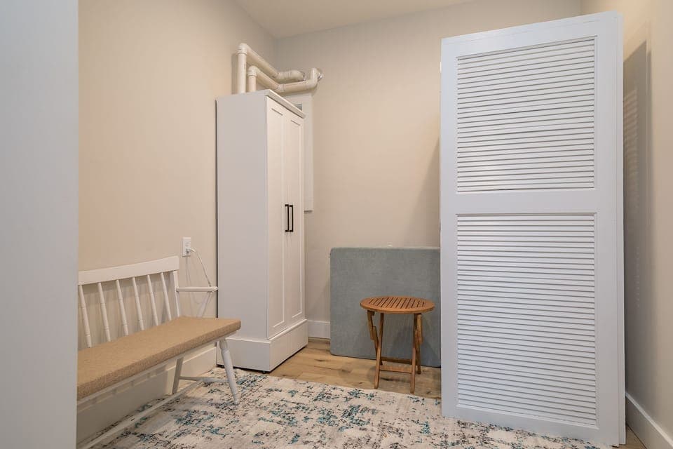 Main floor laundry room with stackable washer and dryer and on-demand water heater