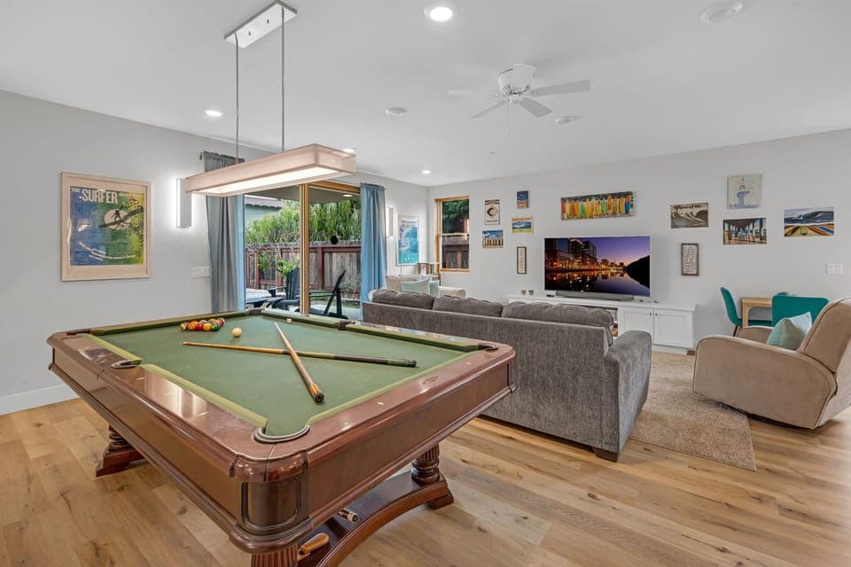 Downstairs living area: pool table, smart TV, kitchenette, direct access to the back patio and alley.