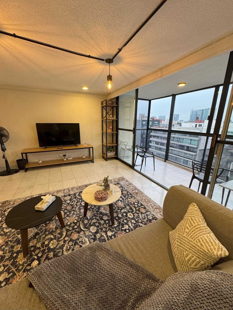 Relax in a bright living room that opens to the balcony, offering cozy seating and skyline views.
