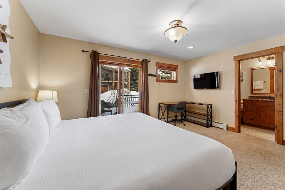 Lower level suite with king size bed, mounted flat screen TV, desk space, en suite bathroom and a dedicated entrance with its own patio.