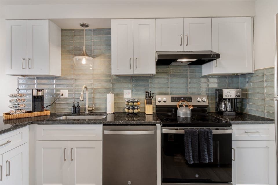 Chic kitchen with turquoise tile backsplash and sleek appliances, blending style and practicality.