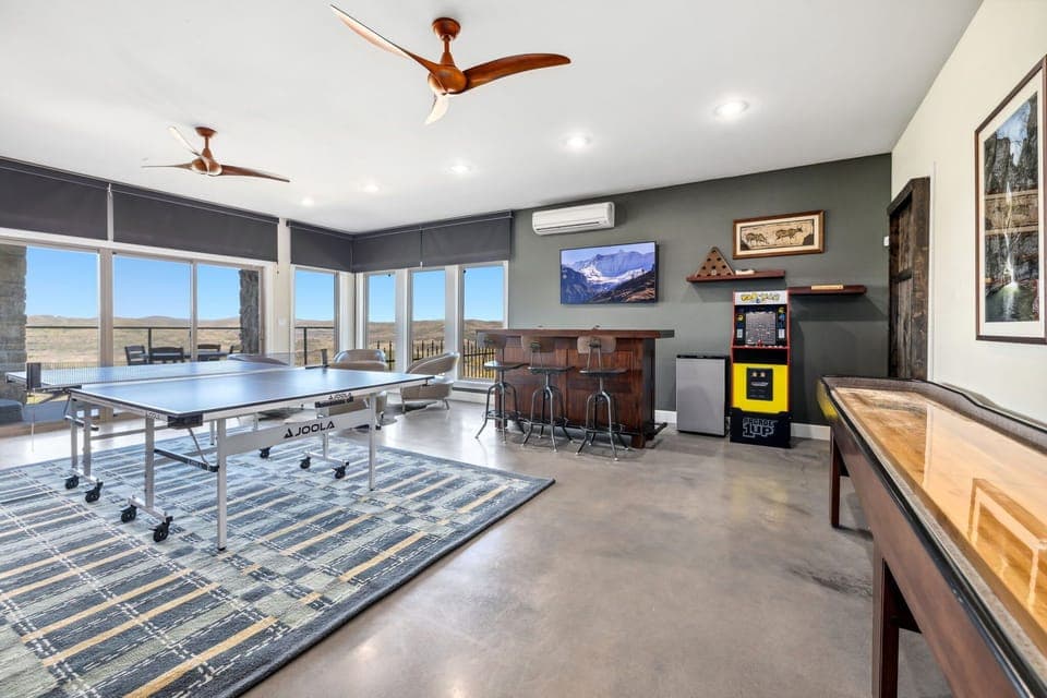 Game room featuring a ping pong table, a shuffleboard table, and arcade games!