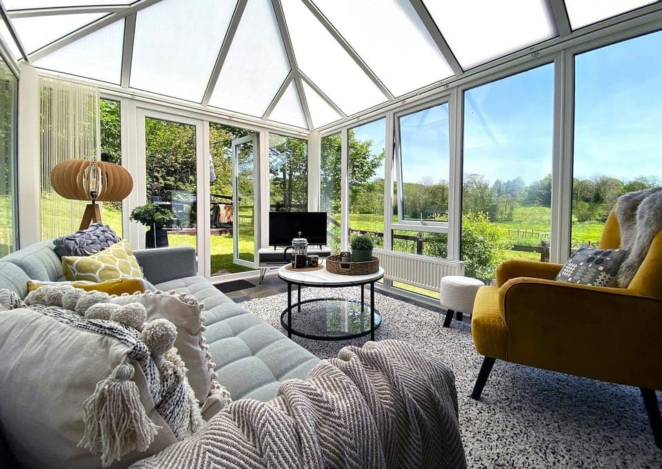 Conservatory lounge area with sofa, coffee table, tv