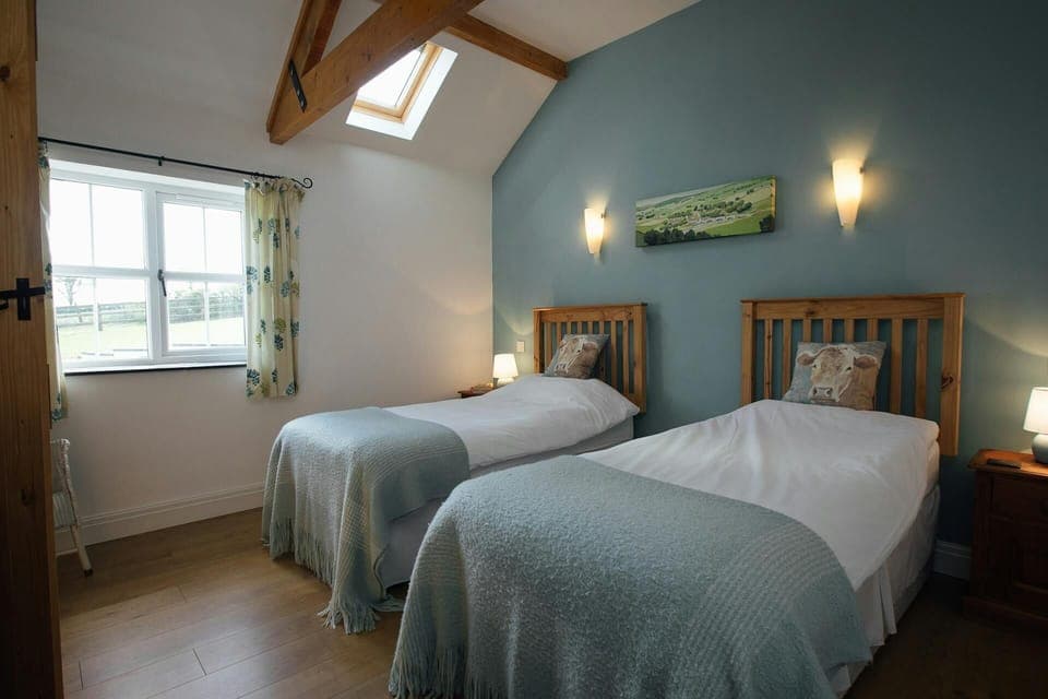 Twin single beds, bedside cabinets with lamps and countryside views from the window