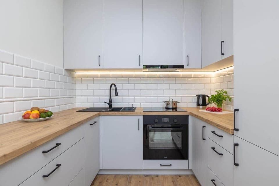  Fully equipped kitchen with modern appliances and a wooden countertop.