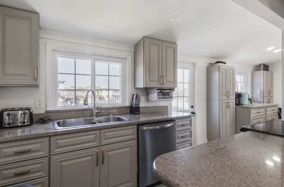 Your fully equipped kitchen invites culinary adventures with granite countertops, stainless steel appliances, and bright natural light streaming through windows.
