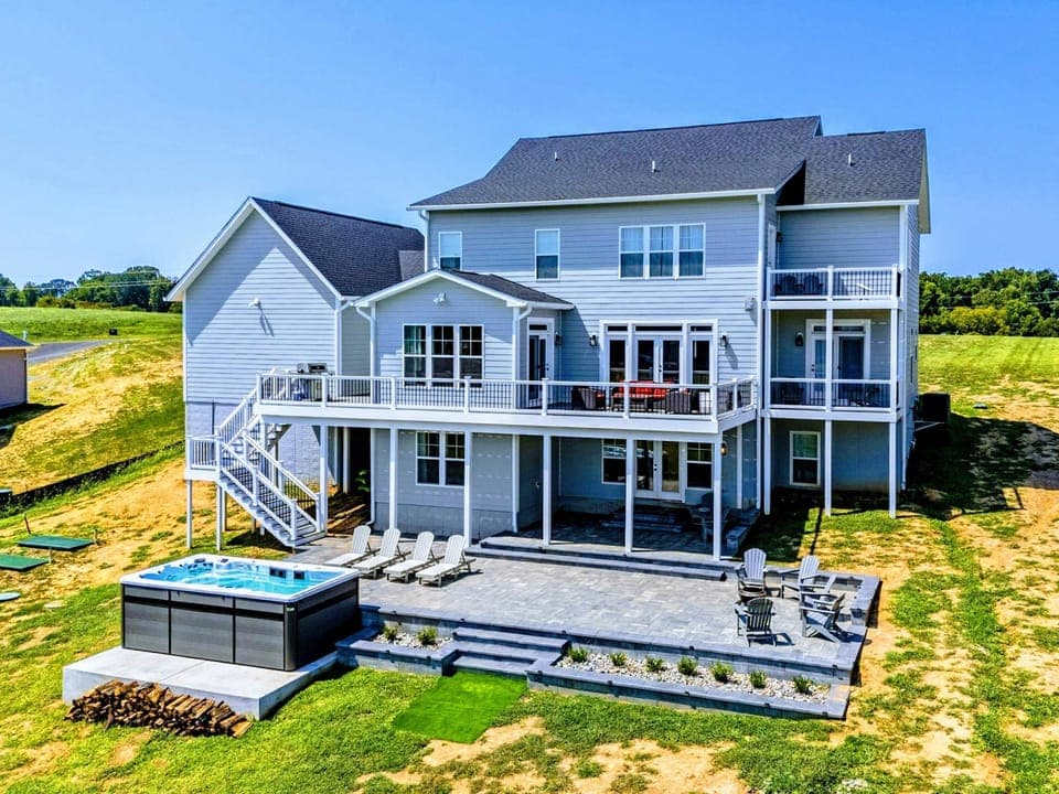 Backyard - Aerial view of the full property, the home and its private lakefront shoreline framed by open water and quiet cove.