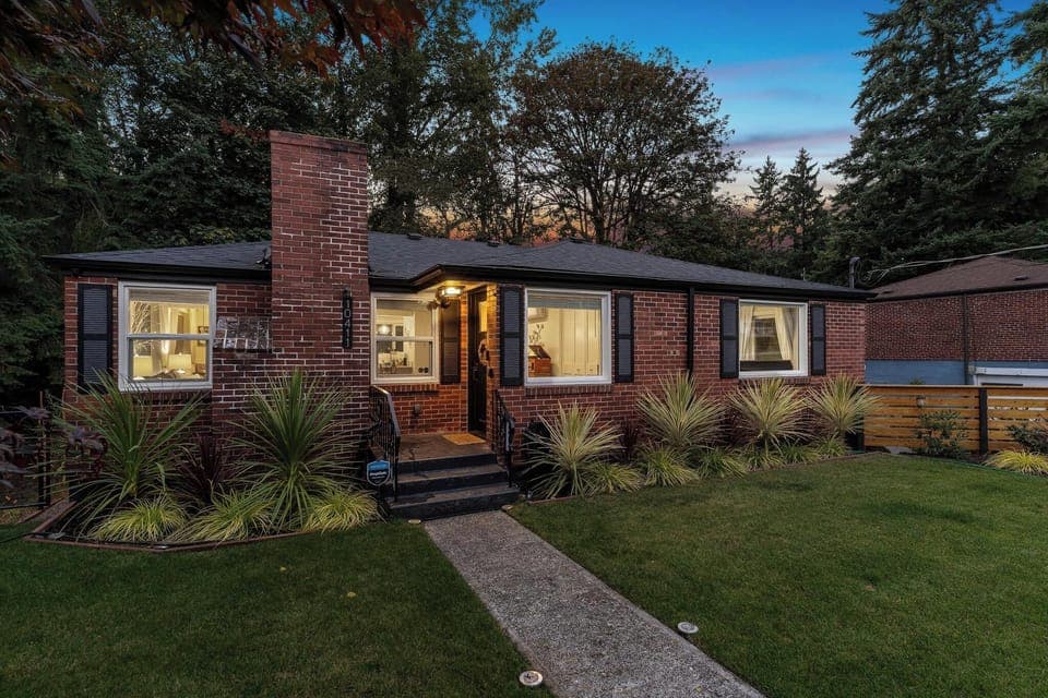 - Stunning evening view of brick home with warm lighting  
- Inviting exterior and green lawn welcome every guest  
- Cozy retreat surrounded by trees and natural beauty  