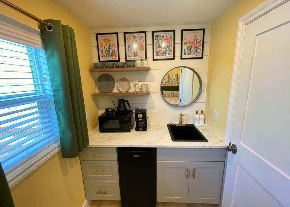 Kitchenette (no range) features micro,frig,coffee, dinnerware, & floral art. 