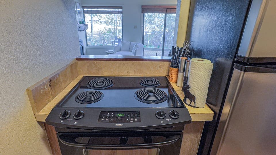 [Kitchen] Galley kitchen includes oven, fridge, dishwasher, microwave, pots/pans