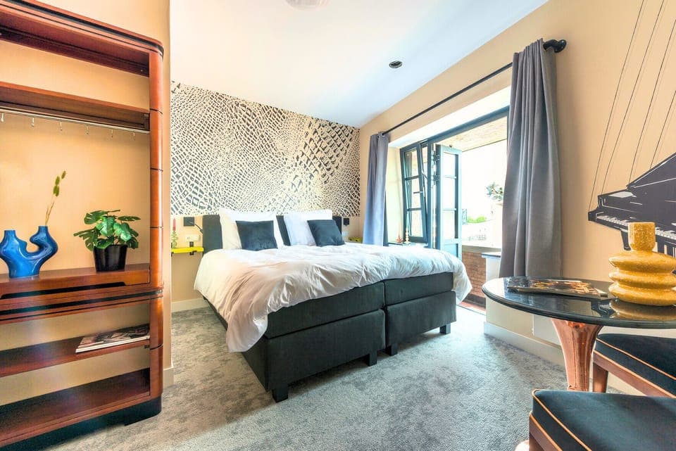 Wake up to beautiful views and abundant sunlight in this spacious bedroom.

Book a cheap stay at a central Tilburg hotel with modern studio apartments. Great for Efteling, Beekse Bergen, or city exploring