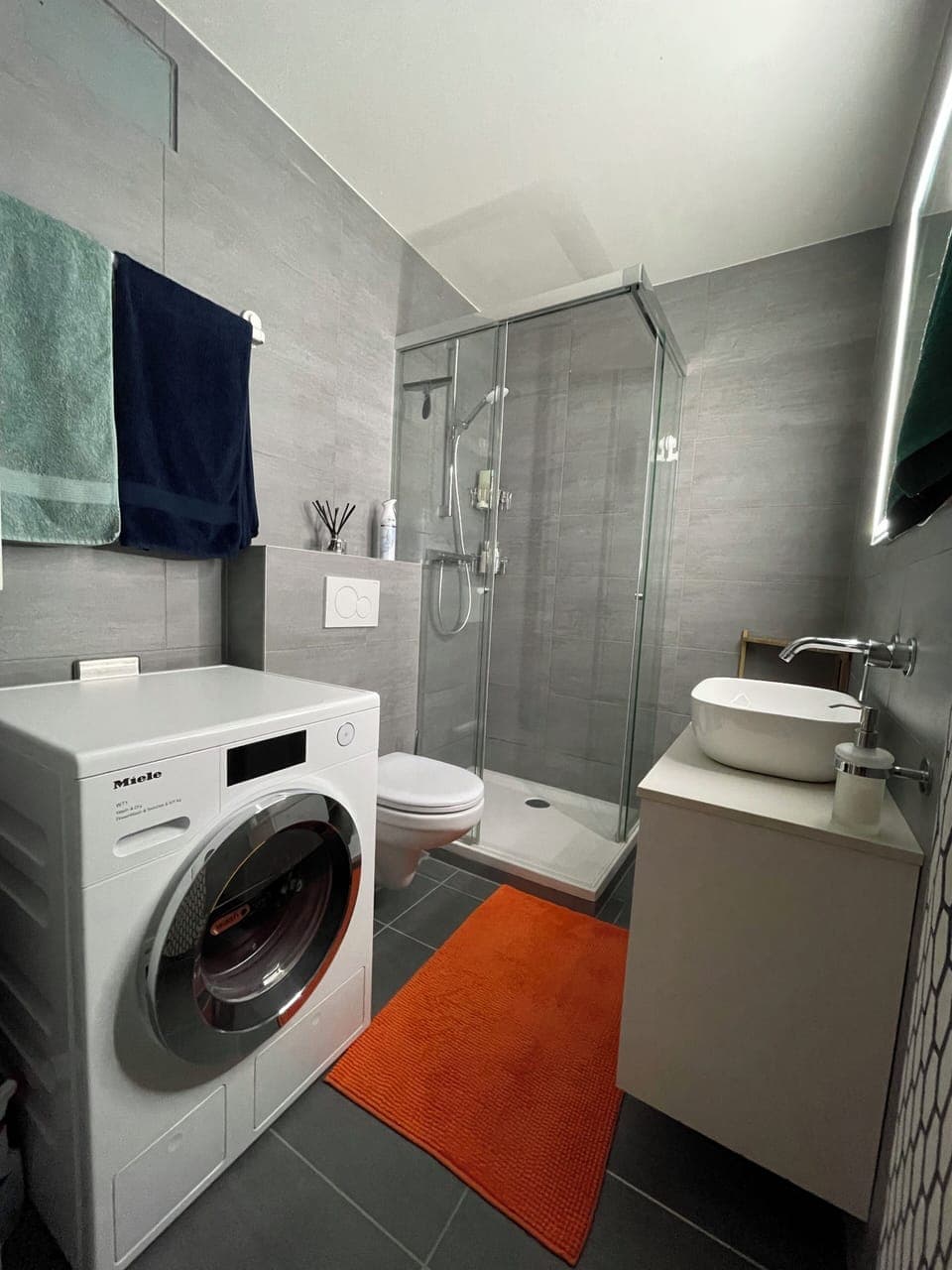 Modern bathroom with a shower and a washing machine 
