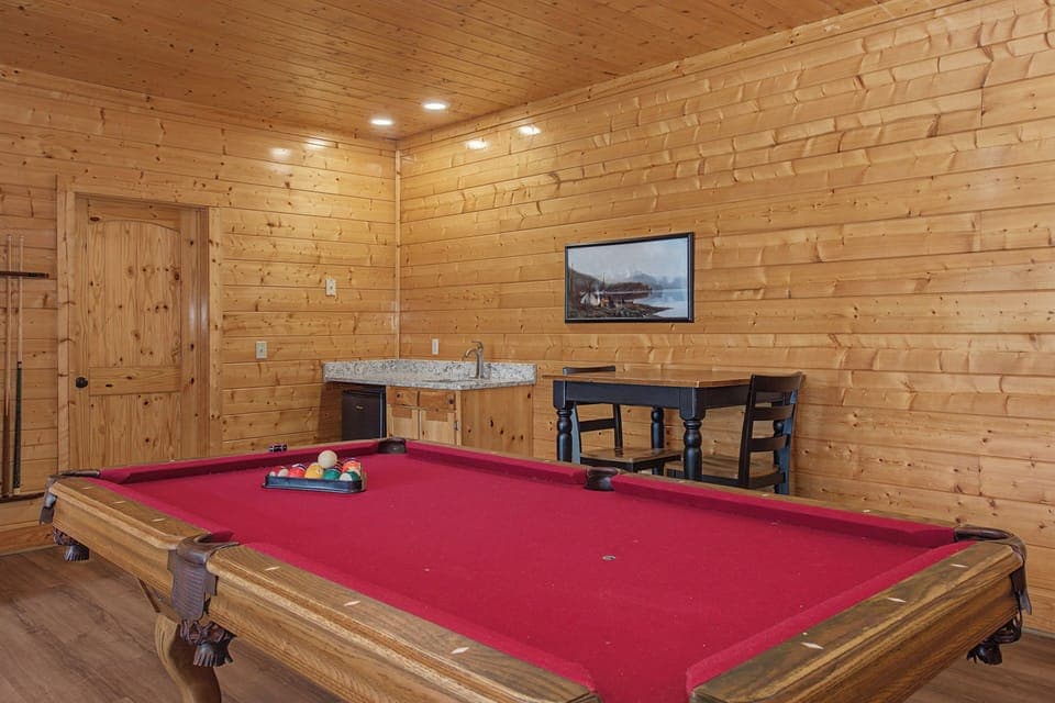Challenge friends to a game in your private billiards room, featuring rustic wood walls and cozy cabin charm.