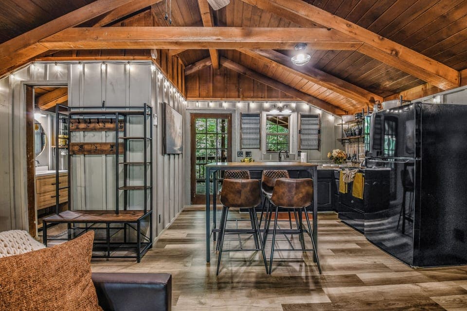 Sleek modern kitchen with black cabinetry, bar seating, and open layout at Light'n Bug Bungalow studio cabin in Townsend, Tennessee near the Great Smoky Mountains